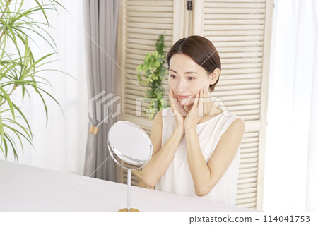 Middle-aged woman doing facial care at home Middle-aged woman doing facial care at home 114041753