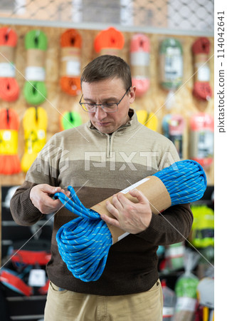Man view rope cable for climbing and evaluate its thickness 114042641