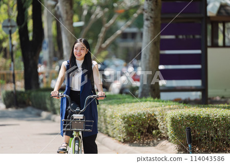 Professional Business woman with bike in the morning walking in the street to work. Eco friendly 114043586