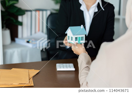 real estate agent talk about terms of home purchase agreement and ask Muslim customer to sign document to make the contract legally 114043671