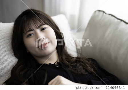 年輕女子躺在沙發上放鬆 114043841