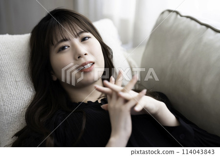 Young woman lying on the sofa and relaxing Young woman lying on the sofa and relaxing 114043843