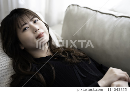 Young woman lying on the sofa and relaxing 114043855