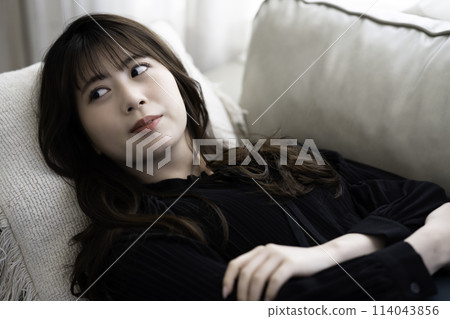 Young woman lying on the sofa and relaxing 114043856