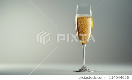 A glass of champagne is sitting on a table 114044636