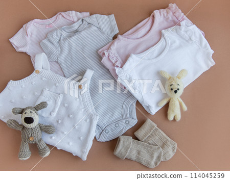 Set of pink clothes and accessories for newborn baby. Knitted toys rabbit and dog, romper, socks and handband 114045259