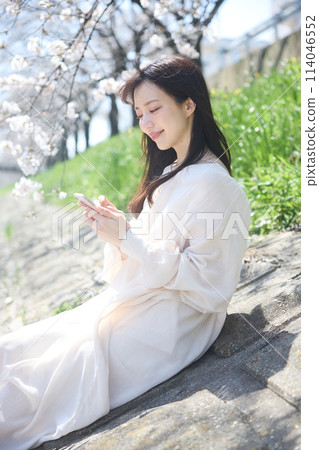 櫻花下看智慧型手機的女人 114046552
