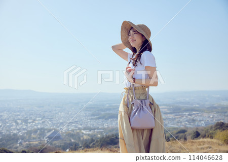 Woman on top of a hill gazing into the distance 114046628
