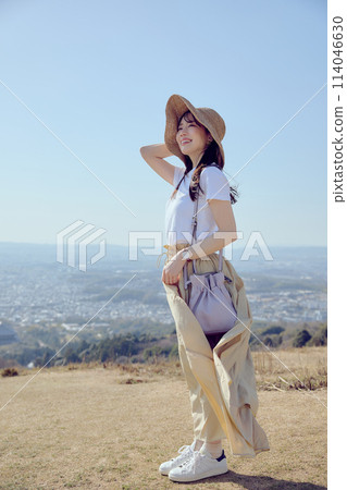 Woman on top of a hill gazing into the distance 114046630