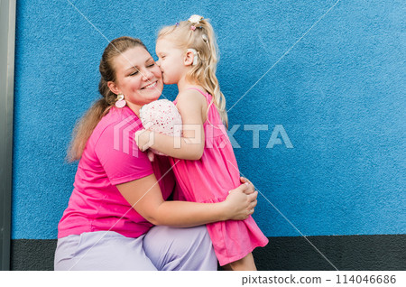 Blonde little girl with cochlear implant playing with her mother outdoor. Hear impairment deaf and health concept. Disability and inclusion. Copy space Blonde little girl with cochlear implant playing with her mother outdoor. Hear impairment deaf and health concept. Disability and inclusion. Copy space 114046686