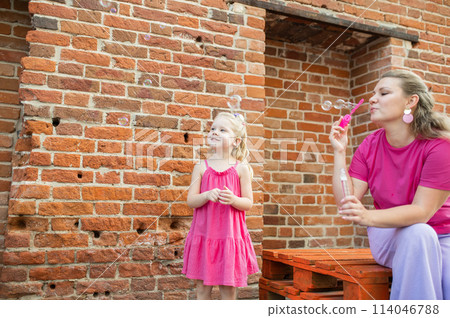 Child girl with cochlear implant with her mother spend time outdoor. Hear impairment and deaf community concept. Deaf and health concept. Disability and inclusion. Copy space Child girl with cochlear implant with her mother spend time outdoor. Hear impairment and deaf community concept. Deaf and health concept. Disability and inclusion. Copy space 114046788