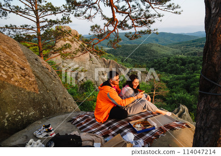 happy couple having date at the cliff on sunset 114047214