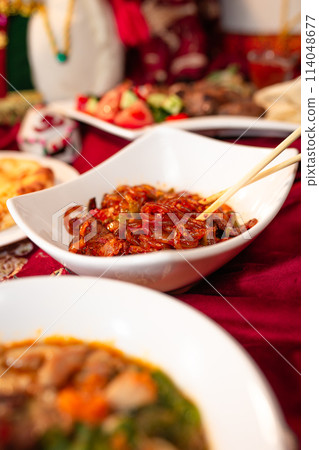 Delectable Noodles with Meat and Vegetables on a Red Tablecloth Delectable Noodles with Meat and Vegetables on a Red Tablecloth 114048677