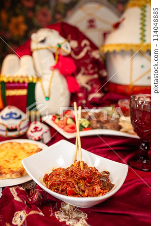 Delectable Noodles with Meat and Vegetables on a Red Tablecloth Delectable Noodles with Meat and Vegetables on a Red Tablecloth 114048885