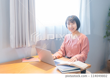 A woman studying at home/working remotely 114049802