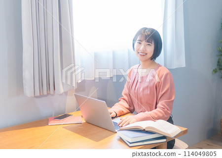 A woman studying at home/working remotely 114049805