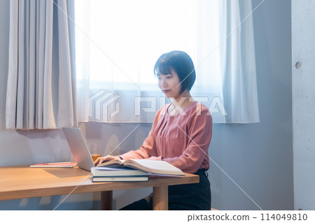 A woman studying at home/working remotely 114049810