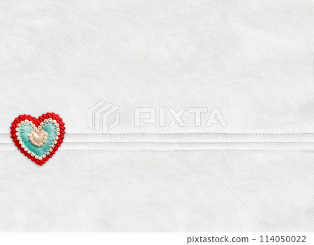 Horizontal Christmas backdrop with suede texture of ivory color and felt heart.  Can be used for scrapbooking winter design. Warm winter time background. Copy space for text 114050022