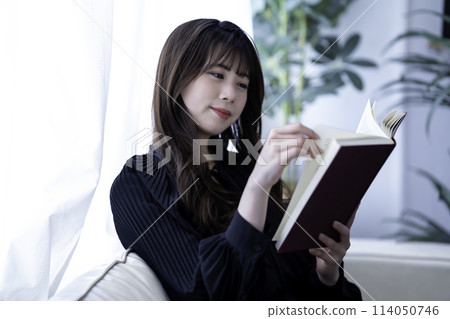 Young woman reading on the sofa on holiday Young woman reading on the sofa on holiday 114050746