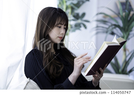 度假時在沙發上看書的年輕女子 114050747