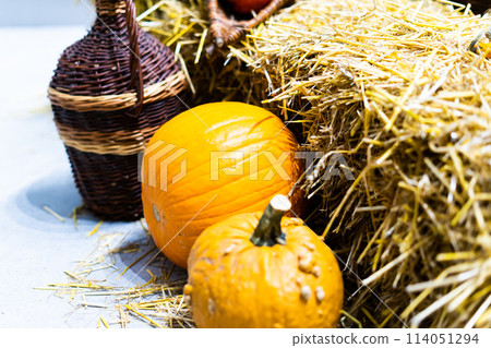 Orange halloween pumpkins on stack of hay or straw in sunny day, fall display 114051294