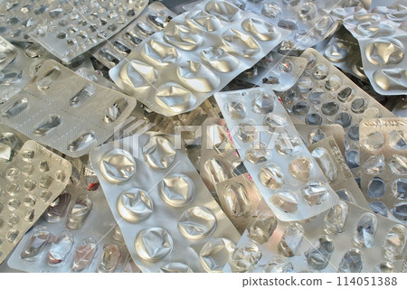 Pile of empty pill blister packs. Treatment and medication concept. Empty blister packages for recycling. Separate garbage sorting. Close up of clinical waste. Reducing medical waste disposal Pile of empty pill blister packs. Treatment and medication concept. Empty blister packages for recycling. Separate garbage sorting. Close up of clinical waste. Reducing medical waste disposal 114051388