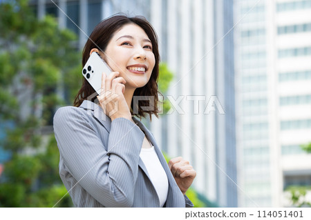在商業區使用智慧型手機的年輕女性 在商業區使用智慧型手機的年輕女性 114051401