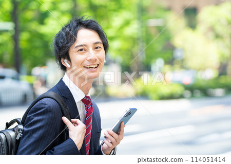 Businessman wearing wireless earphones 114051414