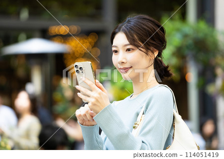 A woman who uses a smartphone in the city 114051419