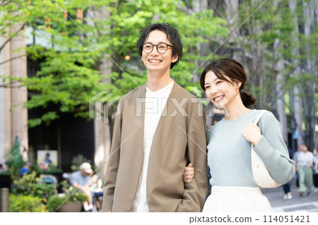 Smiling young couple walking through the city Smiling young couple walking through the city 114051421