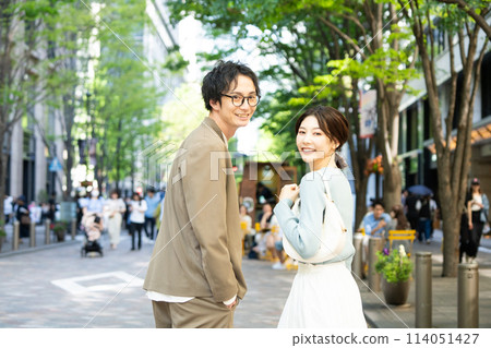 微笑著在城裡散步的年輕夫婦 114051427