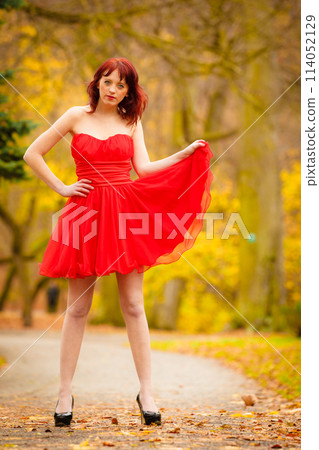 Fashion woman red dress relaxing walking in park 114052129