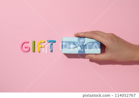 The word "gift" is made of colored plasticine, laid out on a pink background. 114052767