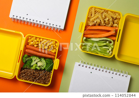 Yellow lunch box with healthy food and notebooks 114052844