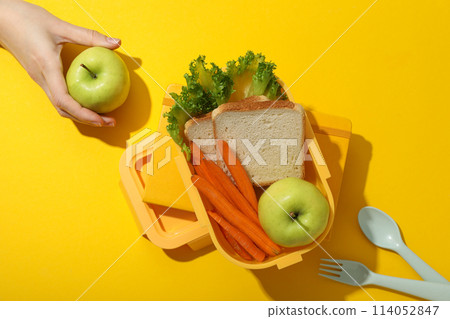 Yellow lunch box with healthy food on a yellow background 114052847