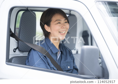 穿著工作服駕駛卡車的中年婦女、運輸和送貨行業的形像等。 穿著工作服駕駛卡車的中年婦女、運輸和送貨行業的形像等。 114052917