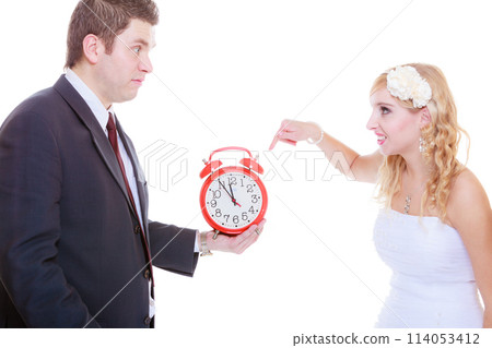 Groom holding big red clock yelling and bride Groom holding big red clock yelling and bride 114053412