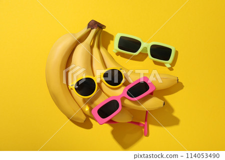 Bananas and sunglasses on yellow background, top view Bananas and sunglasses on yellow background, top view 114053490