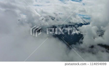 Aerial view of snowcapped mountains in clouds 114054099