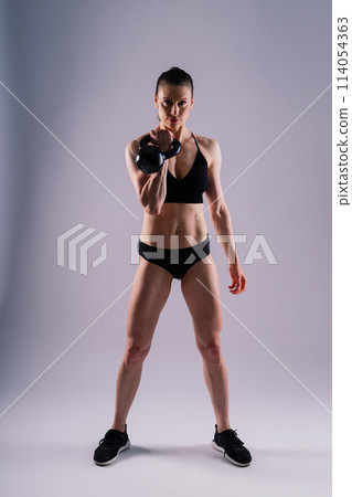 Sport, active lifestyle concept. Smiling strong and slim fitness female athlete holding kettlebell 114054363