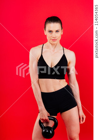 Sport, active lifestyle concept. Smiling strong and slim fitness female athlete holding kettlebell Sport, active lifestyle concept. Smiling strong and slim fitness female athlete holding kettlebell 114054365