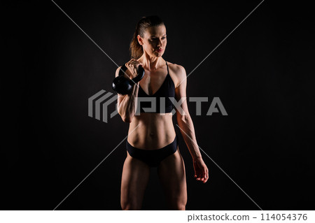 Sport, active lifestyle concept. Smiling strong and slim fitness female athlete holding kettlebell 114054376