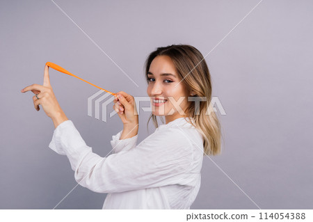 Portrait of beautiful woman with a ballon in hands on grey background in studio 114054388