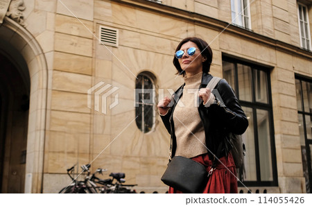 Attractive Woman In Sunglasses Walks In City With Backpack, Female Tourist Looking Around Attractive Woman In Sunglasses Walks In City With Backpack, Female Tourist Looking Around 114055426