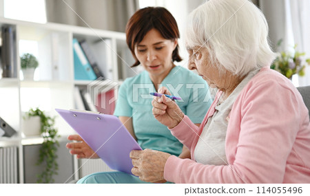 Nurse Helping For Elderly Woman For Sign Documents At Nursing Home Nurse Helping For Elderly Woman For Sign Documents At Nursing Home 114055496