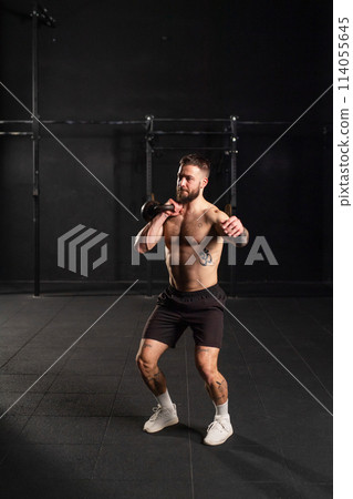 Man lifting a weight with hand, one arm dumbbell snatch, bare chest. Routine workout for physical and mental health. 114055645