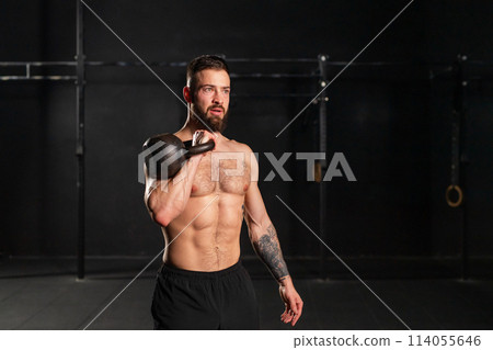 Man lifting a weight with hand, one arm dumbbell snatch, bare chest. Routine workout for physical and mental health. 114055646