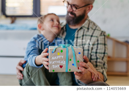 Dad get a handmade gift from little son, present wrapped in diy homemade wrapping paper. Happy Fathers day concept. 114055669