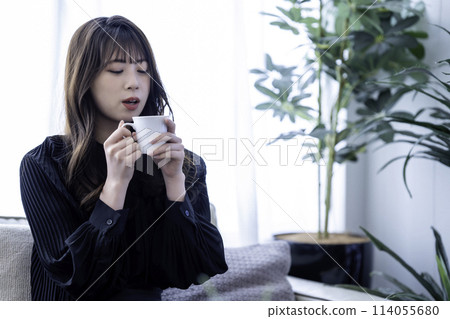 Young woman drinking coffee on the sofa 114055680