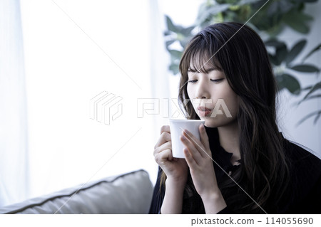 Young woman drinking coffee on the sofa 114055690